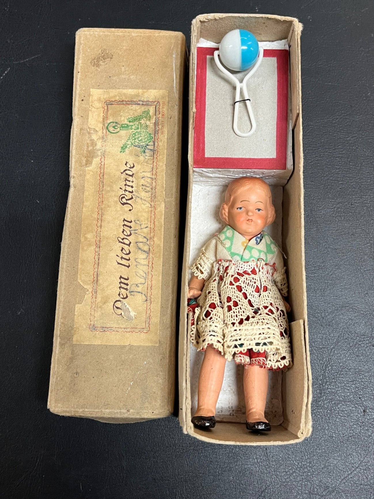Alte kleine Puppe im Karton Dem lieben Kinde mit Rassel Zubehör